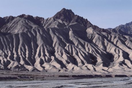 Sédiments ravinés, Pamir, Xinjiang. Quoique récentes, les hautes montagnes de la rivière Gez sont déjà ravinées par le ruissellement, illustrant le pouvoir de destruction des eaux météoriques sur les roches tendres, telles que les limons et les graviers. Dans les régions semi-arides de l’Asie centrale, un seul orage peut appronfondir les ravines d’un mètre.