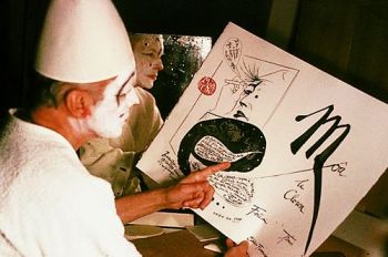 Trémois grimé en clown tenant une planche de son livre "Moâ le Clown"