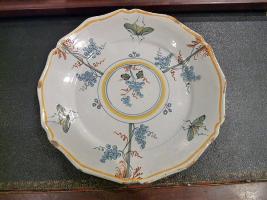 Assiette à bord contourné décor polychrome de pampres de vigne et grappes de raisin. I8ème Siècle Un modèle de Moustiers (La Rochelle).