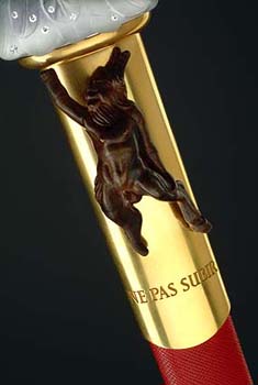 Les ailes évoquent les dieux de la Grèce antique, Apollon et Pan, symboles de rigueur et de folie. La gravure porte la devise "Ne pas subir" et, avec les initiales "H.R.G." d’Hugues Randolph Gall